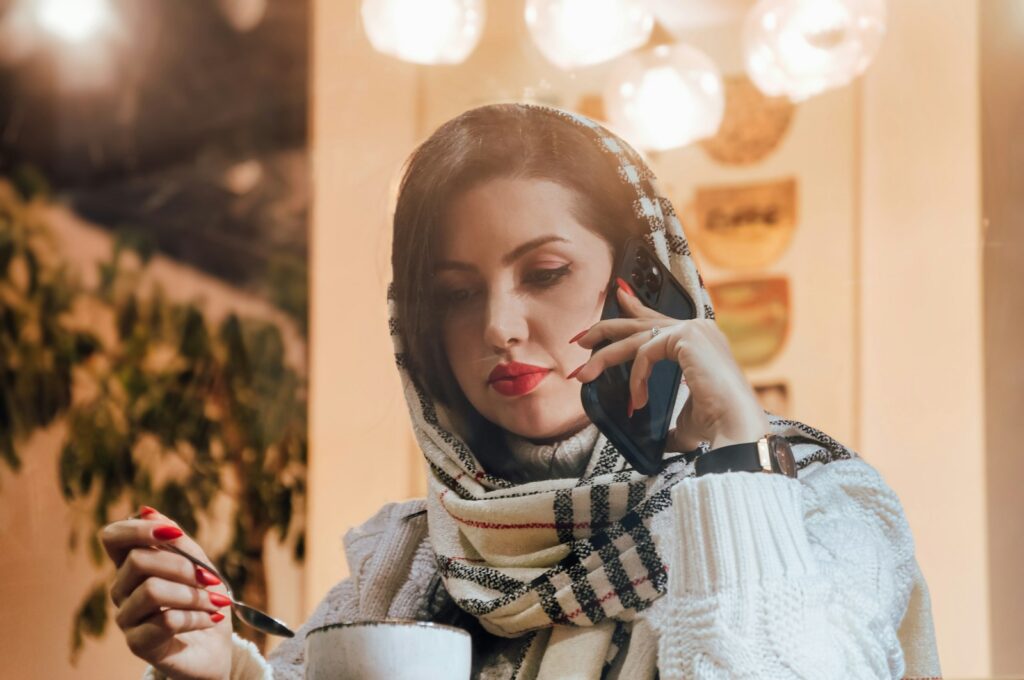 Woman talking on the phone while holding a cup of coffee