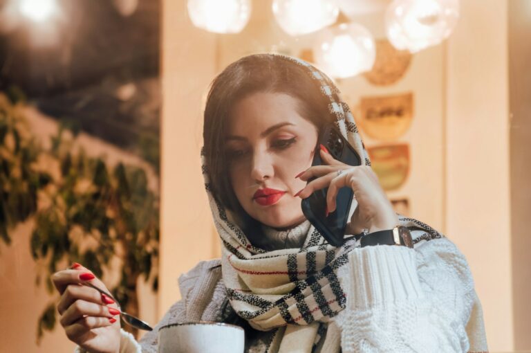 Woman talking on the phone while holding a cup of coffee