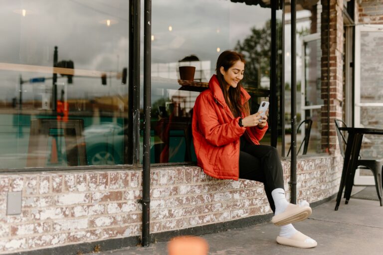 Woman sitting by a window looking at her smartphone