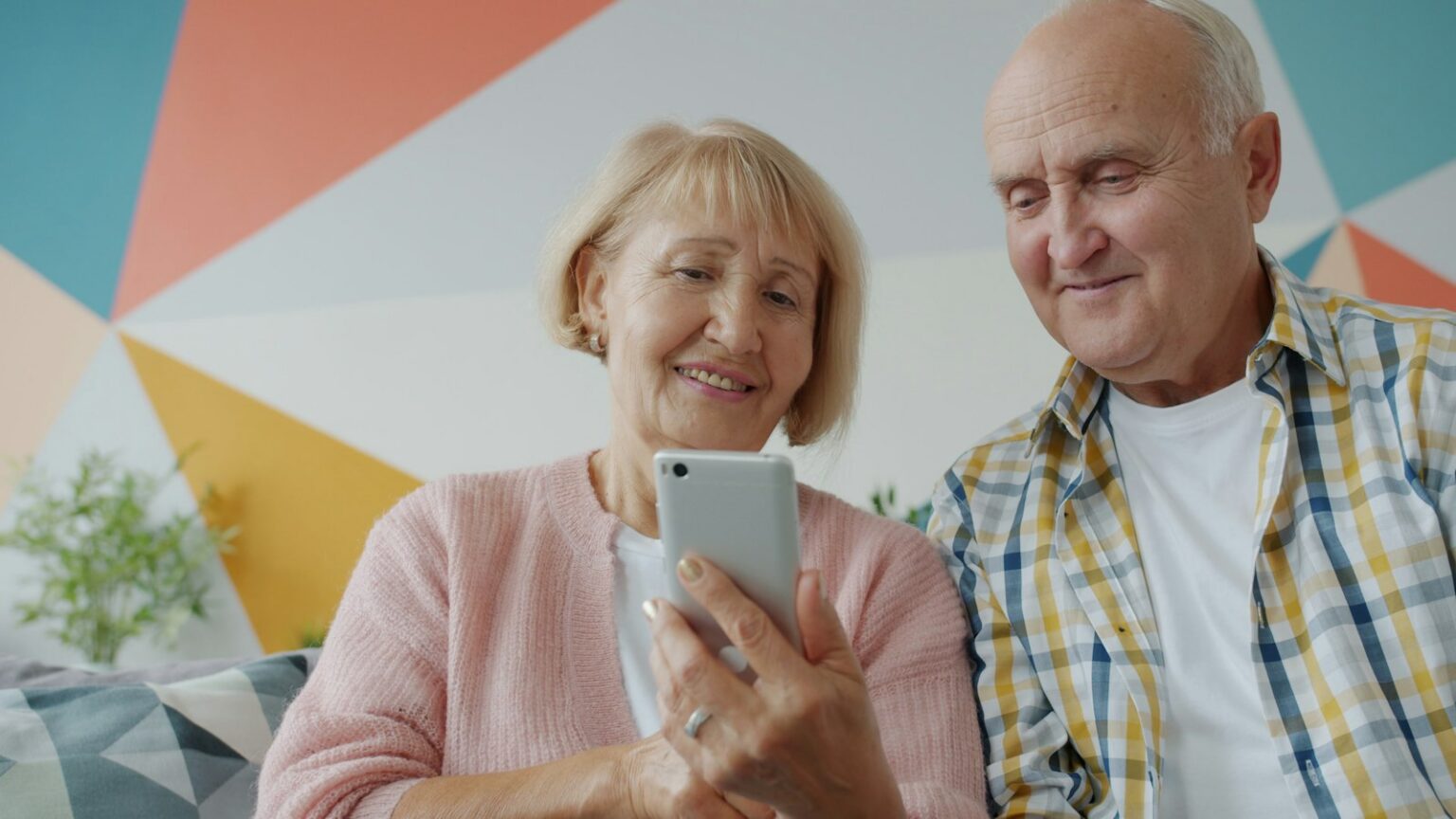Senior couple smiling while using a smartphone together