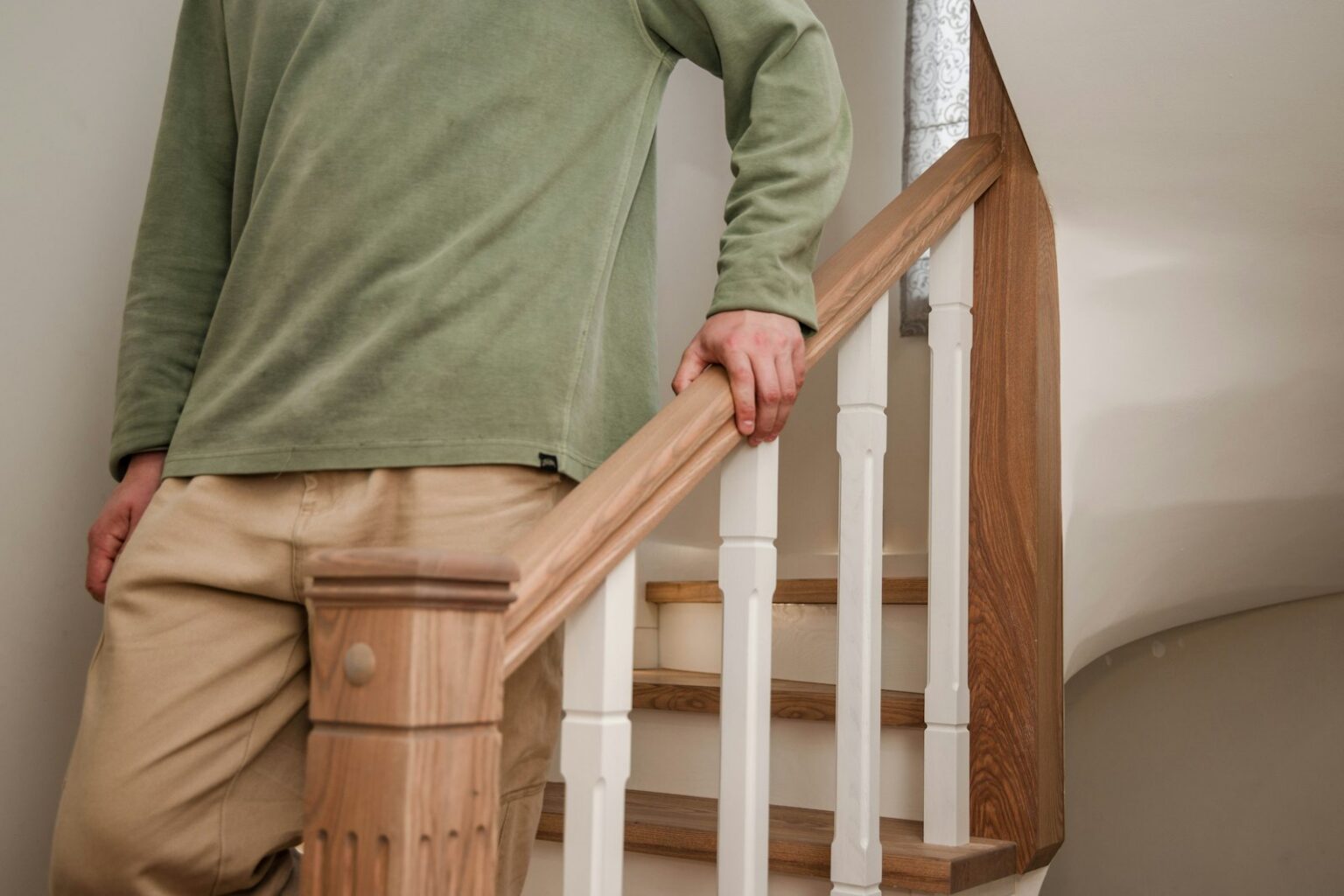 Person walking down the stairs holding the handrail