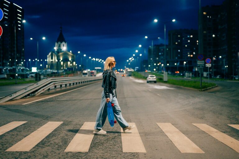 Woman crossing a city street at night