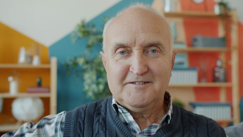 Smiling senior man sitting in his living room