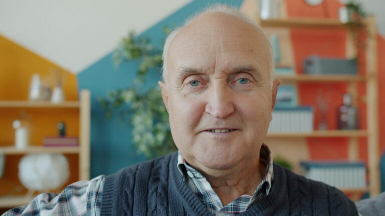 Smiling senior man sitting in his living room