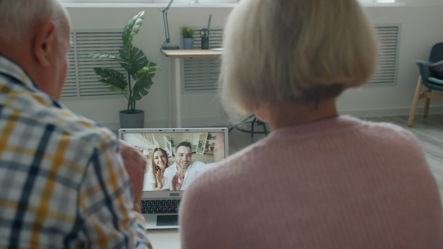 Senior woman on a video call with her family on a laptop at home